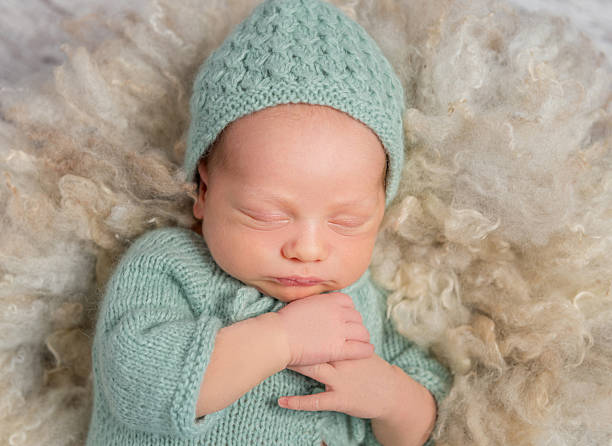 istock lovely newborn in hat and overalls sleeping 637515348
