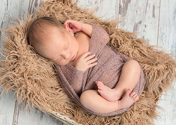 istock lovely sleeping baby wrapped in basket with fluffy blanket 637515518