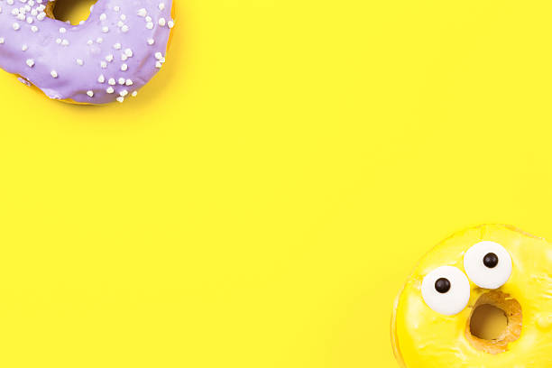istock Round donut with eyes on yellow background. Flat lay, top 637516894