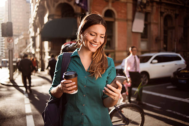 mujer usando teléfono inteligente en la ciudad - freedom on the phone urgency telephone fotografías e imágenes de stock