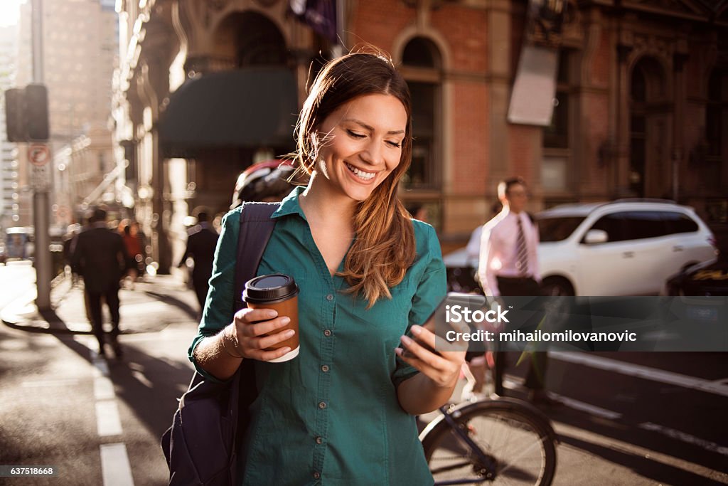 Woman using smartphone in the city Young woman using smartphone in the street Women Stock Photo