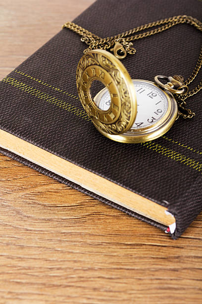 istock Pocket watch and book against a rustic background 637519186