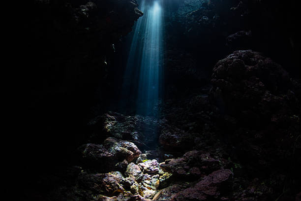 istock Beam of Sunlight in Dark Cavern Underwater 637525604