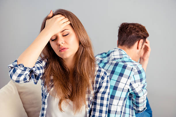 istock sad woman with headache  after quarrel sitting back to husband 637526922