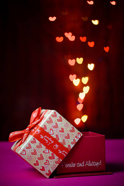 istock gift box open shaped heart with Defocused bokeh colorful lights 637529266