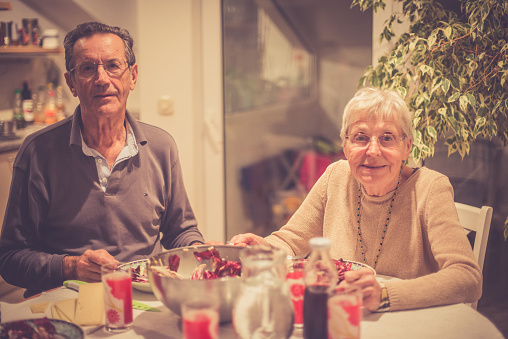 Happy senior Caucasian couple eating radicchio and chees for dinner at home, on the Brač Island in Croatia, Mediterranean, Europe. Copy space. Nikon D800, full frame, XXXL.