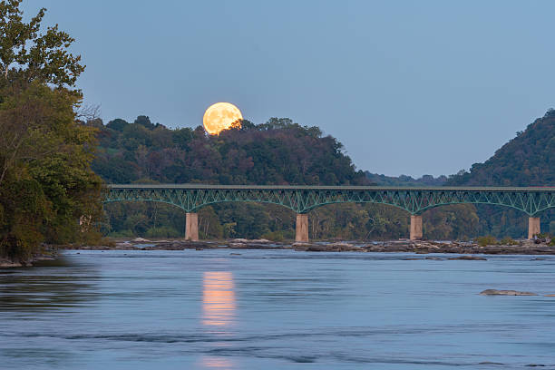 Full Moon Rising Over Bridge The October full moon, sometimes called a Hunter's Moon, rises above the Potomac River and a bridge connecting Maryland and Virginia. harpers ferry photos stock pictures, royalty-free photos & images