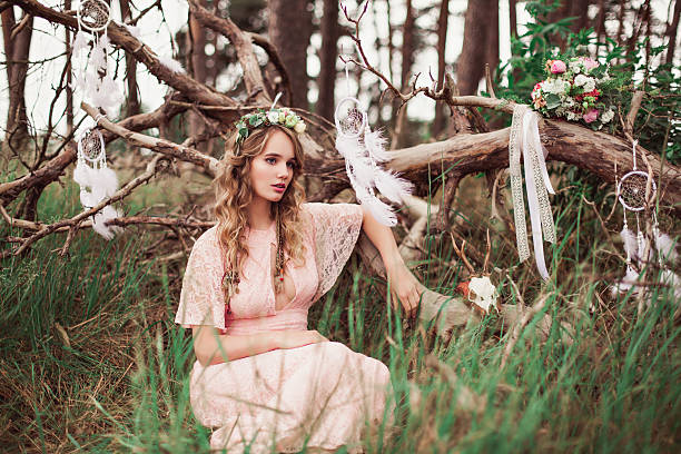 Gorgeous Boho Bride With Dream Catchers In Forest Beautiful boho bride in pink dress holding american indians decoration elements bohemian fashion stock pictures, royalty-free photos & images