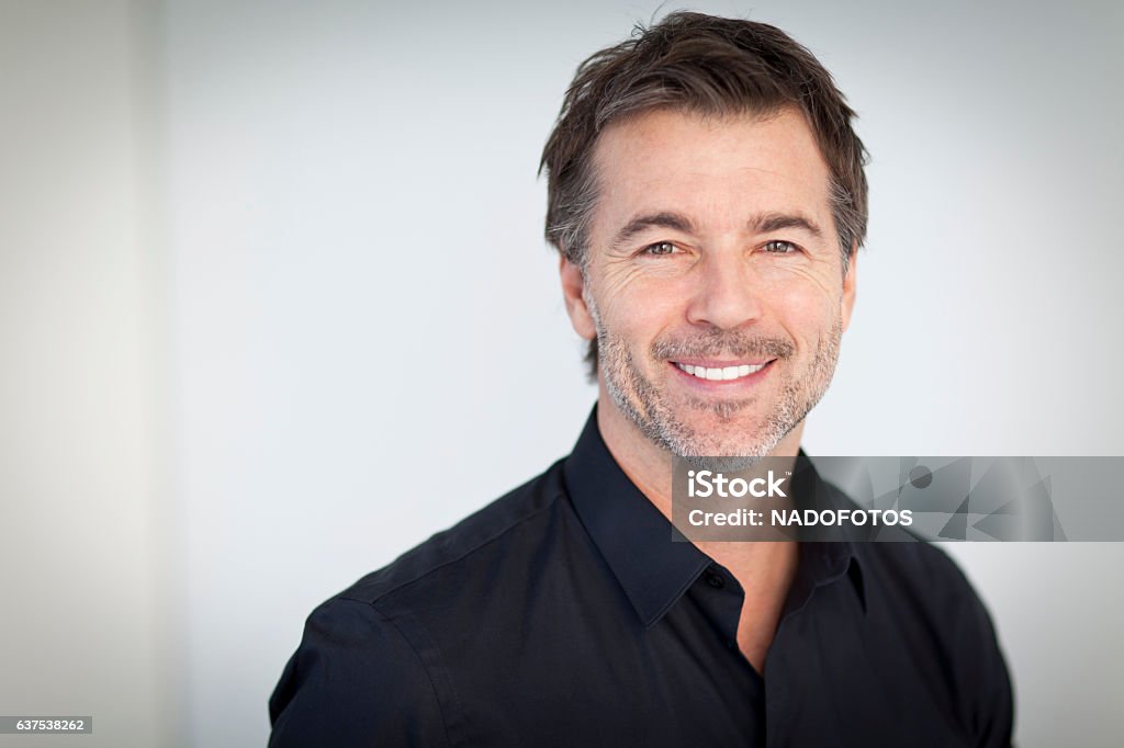 Retrato de un hombre guapo sonriendo aislado sobre blanco - Foto de stock de Hombres libre de derechos