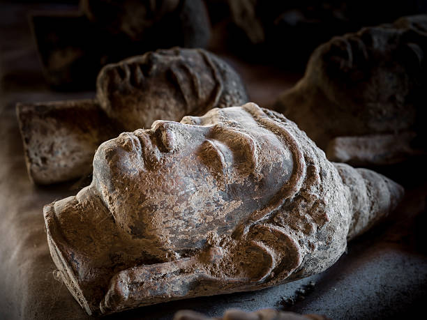A detailed view of a stone carving features a tranquil face surrounded by textured surface, representing the craftsmanship and enduring beauty of ancient monuments. The weathered surface tells a story of time and nature.