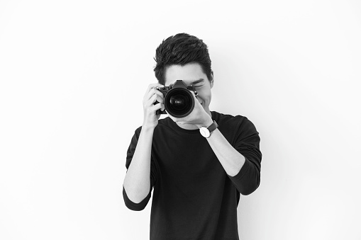 Professional photographer posing in studio holding an SLR Camera