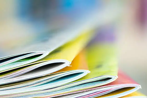 Photo of Close up edge of colorful magazine stacking