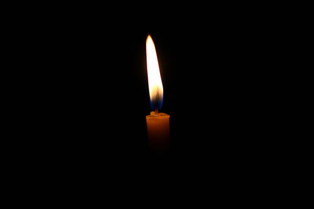 istock One light candle burning brightly in the black background 637548460