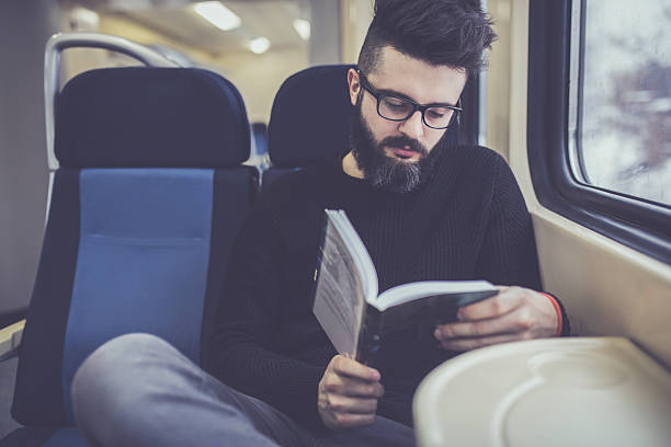 istock Young hipster reading a book on the train 637554204