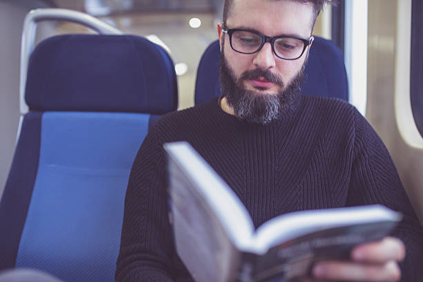 istock Young hipster reading a book on the train 637554330