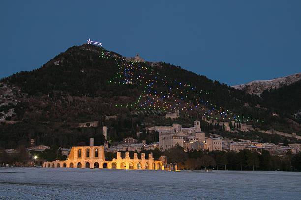 Panoramic view of medieval Gubbio village at night with snow Panoramic view of medieval Gubbio village at night guinnes stock pictures, royalty-free photos & images