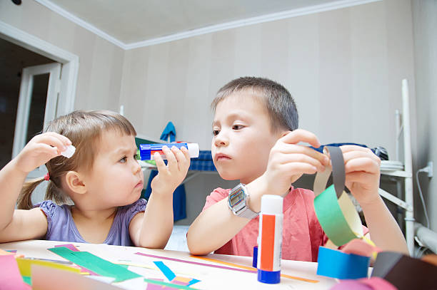 istock children development - brother and sister making craft 637554688