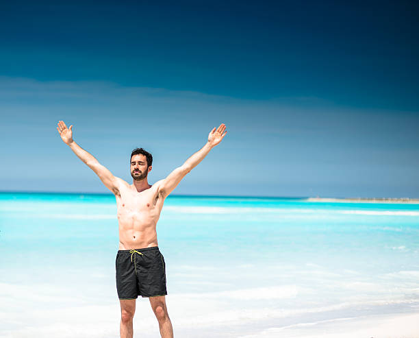 istock man alone in the beach praying to the sun 637555652