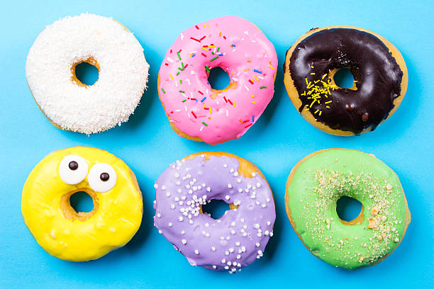 istock Colorful round donuts on blue background. Flat lay, top view. 637556088