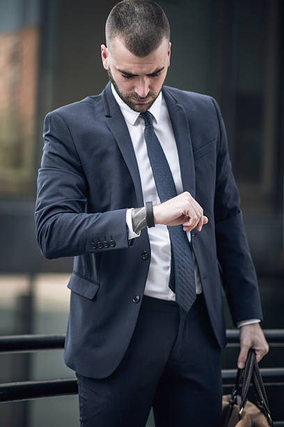 istock Young smart businessman in suit checking smart-watch 637557364