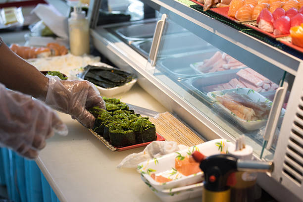 istock chef hand in glove cooking seaweed maki roll 637559690