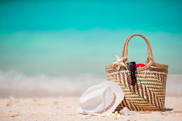 Straw bag, fist star, headphones, hat and sunglasses on white Beach accessories - bag, straw hat, sunglasses on white beach beach bag stock pictures, royalty-free photos & images