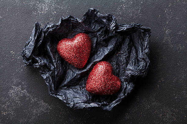istock Valentines day background with pair shiny hearts in black paper. 637567200