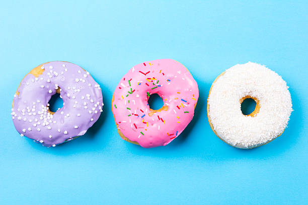 istock Colorful round donuts on blue background. Flat lay, top view. 637567324