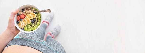 Woman is eating a healthy oatmeal after a workout. stock photo