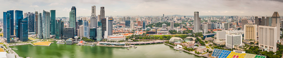 Aerial panoramic view across Singapore's iconic Central Business District skyline, from the landmark Marina Bay developments and the soaring skyscrapers of downtown to the spiky shells of the Esplanade Theatres on the Bay.