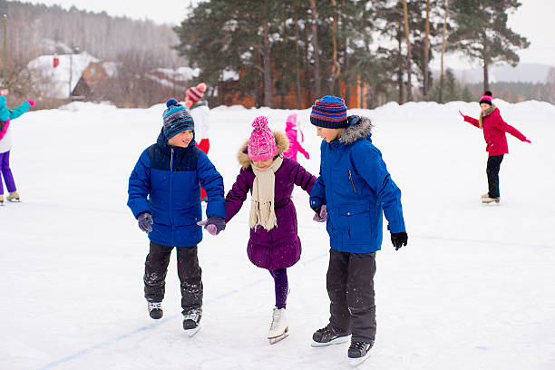 istock two boys helps girl learn to skate 637579338