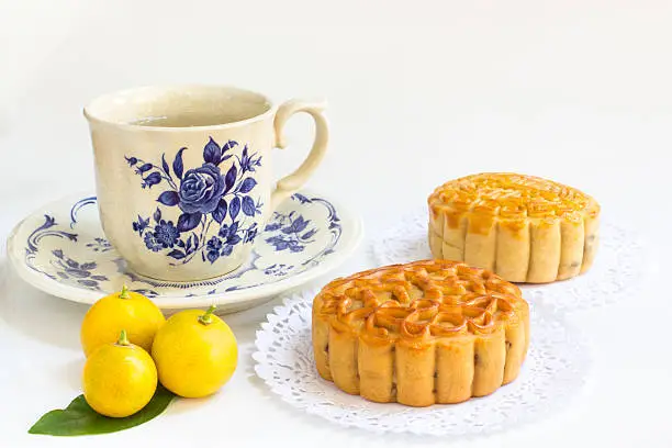 Photo of Traditional mooncake with teacup and small three oranges