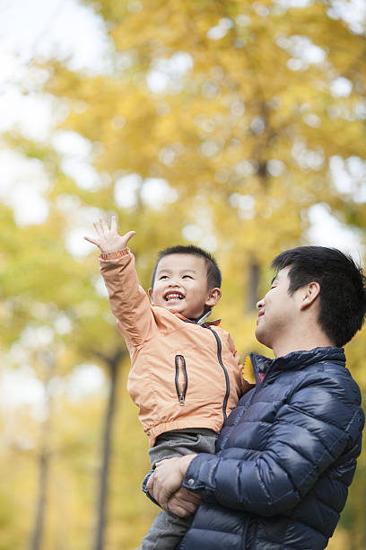 istock Happy real father and son in front of ginkgo trees 637596178