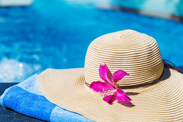 istock Straw hat with orchid flower and blue towel 637598630