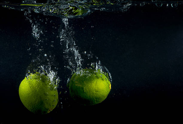 Lime splashing in water on black background