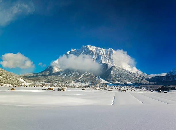 Winter mountains landscape with groomed ski track and dramatic sky, Leutasch, Austria.