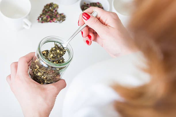 istock Young woman takes green tea on a spoon 637599608