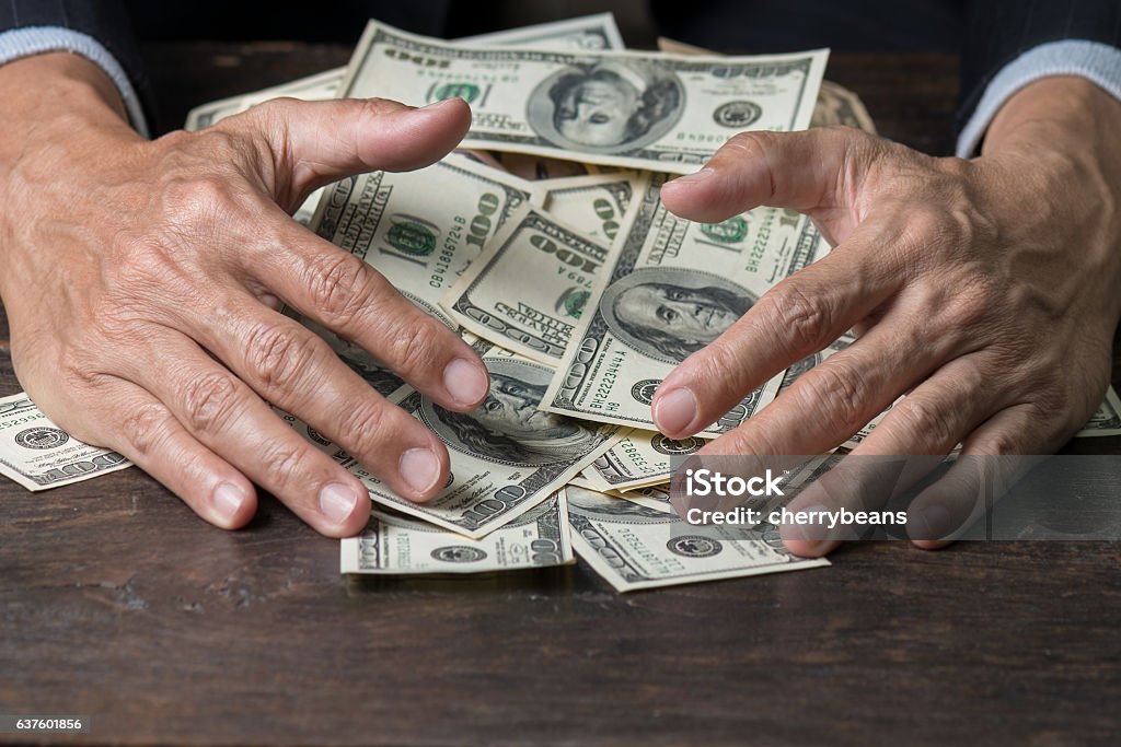 Les mains de l’homme balayant l’argent, le concept d’entreprise. - Photo de Avidité libre de droits