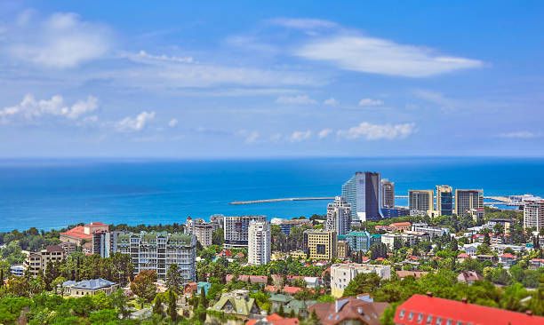 Tilt and shift view of blue coast of Black Sea A tilt and shift view of the blue coast of Black Sea in Sochi with houses under summer cloudy sky sochi stock pictures, royalty-free photos & images