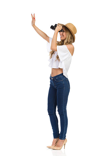 istock Woman Looking Through Binoculars And Waving 637606408