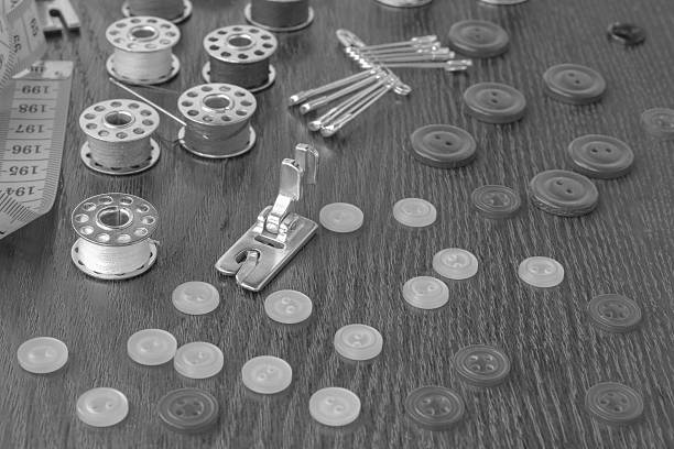 istock Bobbins of thread, buttons, safety pins, sewing foot  on table 637606678