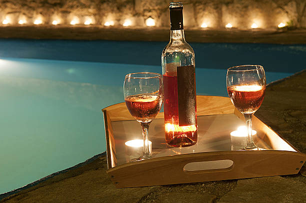 istock bottle of wine at poolside 637608284