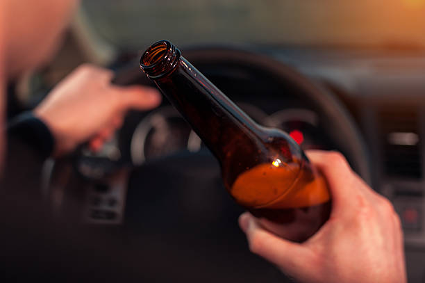istock Male driver hands with steering wheel and beer 637608794