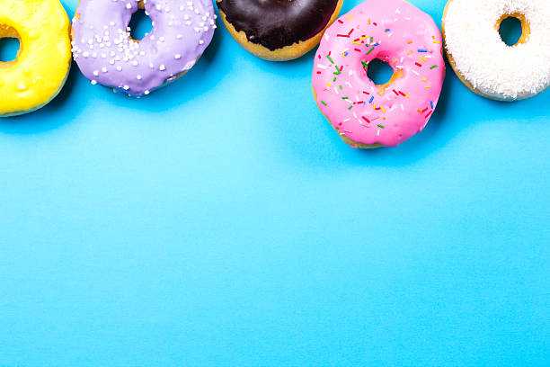 istock Colorful round donuts on blue background. Flat lay, top view. 637612422