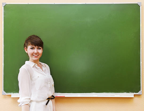 istock Student girl standing near clean blackboard 637613828