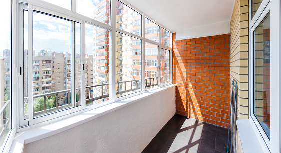 Glazed balcony with brick wall