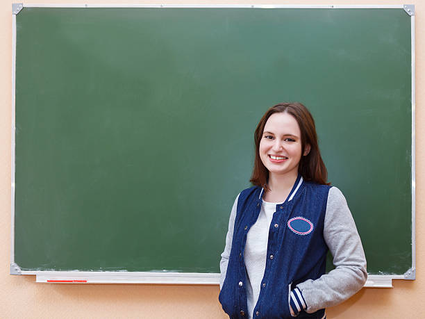 istock Student girl standing near blackboard 637617724