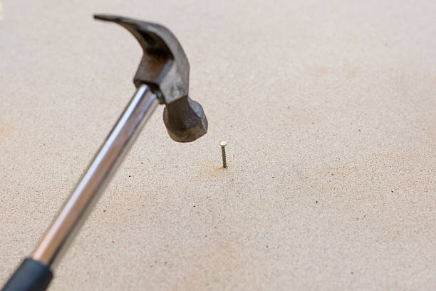 istock Hammer and nails on wood background 637622070