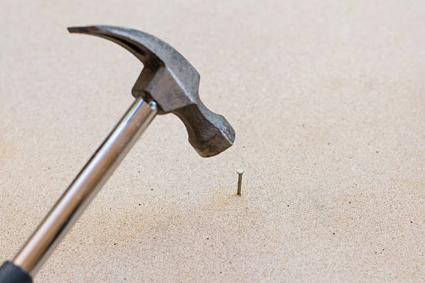 istock Hammer and nails on wood background 637622200