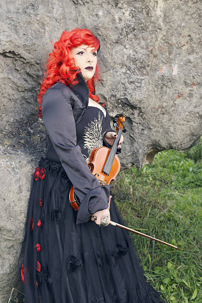istock Redhead woman playing violin outdoors. 637622474